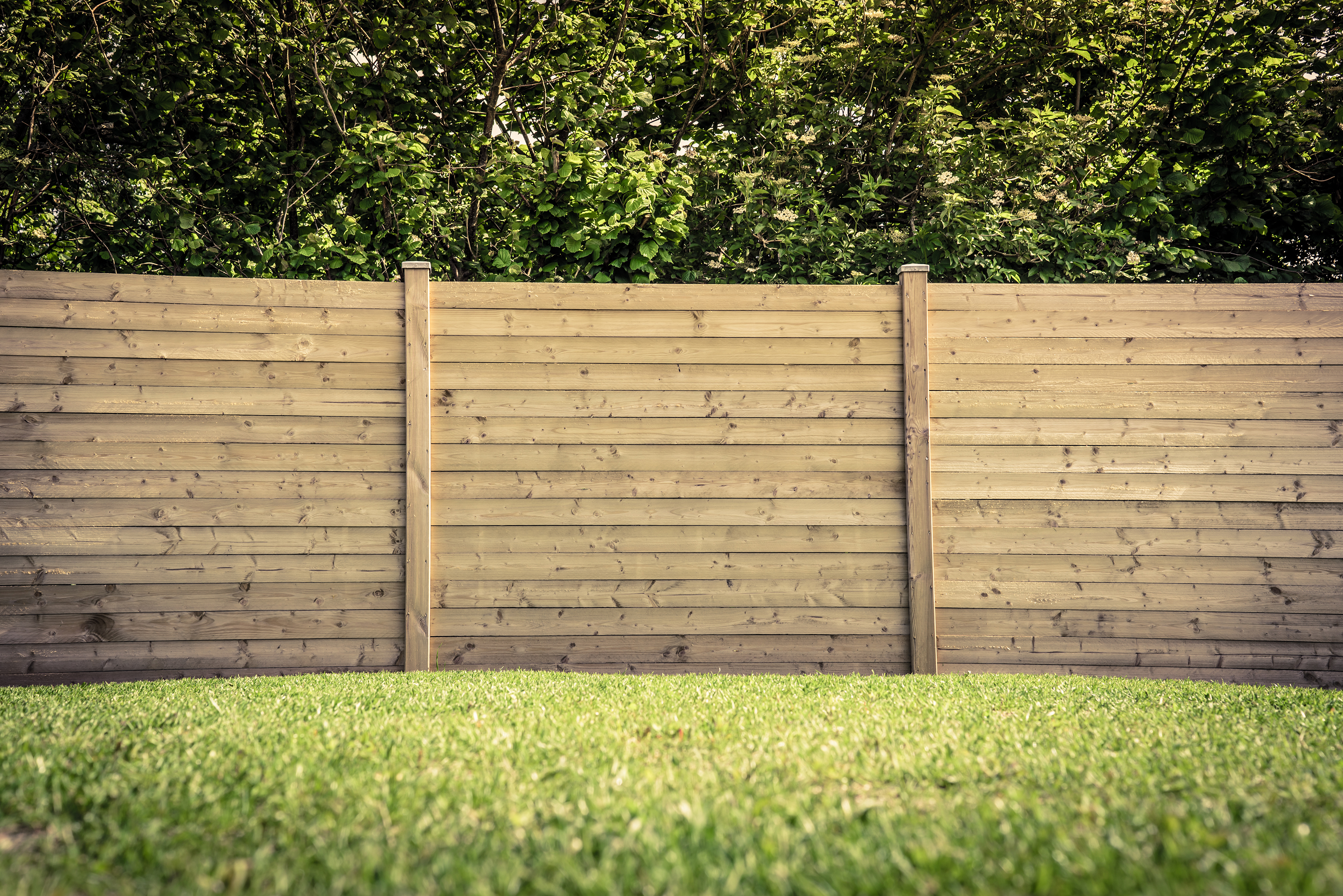 Wooden fence on a green lawn in a garden